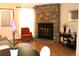 Cozy living room featuring a stone fireplace, hardwood floors, and ample natural light at 10515 W Dartmouth Ave, Lakewood, CO 80227