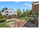 Spacious backyard with a wooden deck, lush green grass, mature trees, and a wooden fence at 2301 Dunbar Ct, Longmont, CO 80501