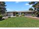 Charming single-story home with a lush green lawn and beautiful front yard landscaping at 2301 Dunbar Ct, Longmont, CO 80501