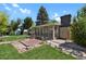 Enclosed sunroom with glass walls surrounded by green lawn, brick walkways and mature trees at 2301 Dunbar Ct, Longmont, CO 80501