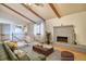 Bright living room featuring a brick fireplace, exposed beams and new wood flooring at 1507 Atwood St, Longmont, CO 80501