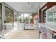 Bright sun room with views of the exterior porch featuring a white bar and a brick wall at 1521 Pontiac St, Denver, CO 80220