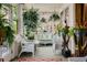Relaxing sunroom filled with plants and wicker furniture, perfect for enjoying the outdoors at 1521 Pontiac St, Denver, CO 80220