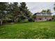 Expansive backyard featuring lush green grass, mature trees, and home's exterior at 1312 Sandstone Ct, Boulder, CO 80305