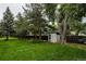 View of backyard with green grass and storage shed with wooden fence at 1312 Sandstone Ct, Boulder, CO 80305