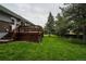 Backyard featuring a wooden deck, a spacious yard, and mature pine trees at 1312 Sandstone Ct, Boulder, CO 80305