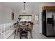 Inviting dining area featuring a wooden table, adjacent living room, and a stainless steel refrigerator at 1312 Sandstone Ct, Boulder, CO 80305