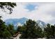 Scenic view of the mountains from the home, framed by lush green trees at 1312 Sandstone Ct, Boulder, CO 80305