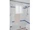 Glass-enclosed shower with white tile, blue trim, and modern fixtures at 1312 Sandstone Ct, Boulder, CO 80305