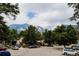 Street view featuring mature trees, mountains in the background, and neighborhood parking at 1312 Sandstone Ct, Boulder, CO 80305
