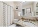 Bathroom featuring a vanity with granite counter, a decorative framed mirror, and a shower with a patterned curtain at 8156 E 35Th Ave, Denver, CO 80238