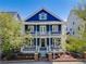Charming two-story blue house with a double porch and well-manicured landscaping at 8156 E 35Th Ave, Denver, CO 80238