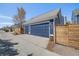 Three-car garage with blue doors and siding, and a wooden privacy fence at 8156 E 35Th Ave, Denver, CO 80238
