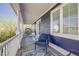 Inviting covered front porch with comfortable seating, blue rugs, and white pillars at 8156 E 35Th Ave, Denver, CO 80238