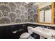 Stylish powder room featuring unique wallpaper, pedestal sink, and modern fixtures creating a sophisticated space at 8156 E 35Th Ave, Denver, CO 80238