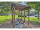 Community gazebo with a metal picnic table, shaded by trees and surrounded by lush greenery at 1612 Cottonwood Dr # 2W, Louisville, CO 80027