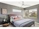 Comfortable bedroom with large windows, gray walls, ceiling fan, and minimalist decor at 1457 Yates St, Denver, CO 80204