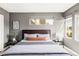 Inviting bedroom with gray walls, plush bedding, and two large windows, providing ample natural light at 1457 Yates St, Denver, CO 80204