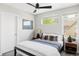 Cozy bedroom with a bed, ceiling fan, and windows offering views of the surrounding neighborhood at 1457 Yates St, Denver, CO 80204