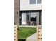 Inviting front entrance with modern brickwork, lush lawn, and stylish outdoor seating area at 1457 Yates St, Denver, CO 80204