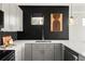 Stylish kitchen featuring stainless steel sink, gray cabinets, modern countertops, and black tiled backsplash at 1457 Yates St, Denver, CO 80204