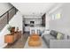 Open-concept living room with modern stairs, view of kitchen, stylish seating and hardwood floors at 1457 Yates St, Denver, CO 80204