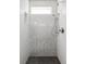 Modern bathroom shower with glass doors, chrome fixtures, and sleek white and silver tiling at 1457 Yates St, Denver, CO 80204
