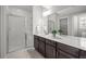 Bright bathroom featuring a glass-enclosed shower, sleek vanity, and a large mirror reflecting the room at 9756 Mount Kataka Pt, Littleton, CO 80125