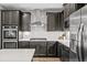 Kitchen featuring stainless steel appliances, white backsplash and dark wood cabinets at 9756 Mount Kataka Pt, Littleton, CO 80125