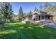 Expansive backyard with lush lawn, stone patio, and covered seating area for outdoor relaxation at 11531 S Deer Creek Rd, Littleton, CO 80127