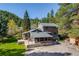 Charming home featuring a stone foundation, screened porch, and surrounded by lush greenery and mature trees at 11531 S Deer Creek Rd, Littleton, CO 80127