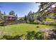 Exterior view of a home showcasing a large yard, second story balcony, and mature trees at 11531 S Deer Creek Rd, Littleton, CO 80127