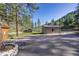 Driveway featuring garage, sheds, and landscaping, adding functionality and beauty to the property at 11531 S Deer Creek Rd, Littleton, CO 80127