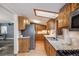 A well-lit kitchen with wood cabinets, stainless steel appliances, and granite countertops offers ample space and functionality at 11531 S Deer Creek Rd, Littleton, CO 80127