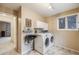 Functional laundry room equipped with washer, dryer, and a wash basin sink at 11531 S Deer Creek Rd, Littleton, CO 80127