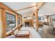 Bright living room featuring wooden beams, a cozy daybed, and access to another living space at 11531 S Deer Creek Rd, Littleton, CO 80127