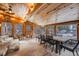 Charming sunroom with wood ceiling, stone accents, large windows, and ample seating, perfect for relaxation and enjoyment at 11531 S Deer Creek Rd, Littleton, CO 80127