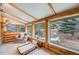 Cozy sunroom with natural wood, large windows, and comfortable seating provides a serene and inviting retreat at 11531 S Deer Creek Rd, Littleton, CO 80127