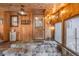 Inviting sunroom with wooden walls, stone steps, and exterior views at 11531 S Deer Creek Rd, Littleton, CO 80127