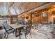 Cozy sunroom featuring wood paneling, stone accents, ample seating, and windows offering scenic views of the outdoors at 11531 S Deer Creek Rd, Littleton, CO 80127