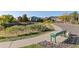 Walking path with a bench in a community with mature trees and mountain views at 7630 Chickaree Pl, Littleton, CO 80125