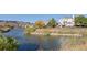 Water view with houses on a lake and rolling mountains in the background at 7630 Chickaree Pl, Littleton, CO 80125