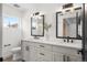 Bright bathroom with double sink vanity, white cabinets, black hardware, and framed mirrors with decorative lighting at 535 Josephine St, Denver, CO 80206