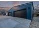 Detached garage with black garage doors and modern blue siding, offering ample parking space at 535 Josephine St, Denver, CO 80206