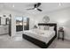 Modern bedroom with dark grey bed frame, white walls and luxury bedding. Glass door to balcony and ensuite bathroom at 535 Josephine St, Denver, CO 80206