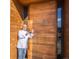 The entrance of Matsuhisa restaurant, featuring a large wooden door and the chef pointing to it at 535 Josephine St, Denver, CO 80206