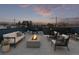 Relaxing rooftop deck featuring a fire pit, comfortable seating, and views of the surrounding neighborhood at 535 Josephine St, Denver, CO 80206
