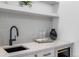 Elegant wet bar area with modern sink, white countertops, wine fridge, and overhead shelving at 535 Josephine St, Denver, CO 80206