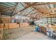 Spacious barn interior with stalls, a boat, hay bales, and high ceilings with exposed beams at 5774 Sioux Dr, Sedalia, CO 80135