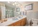 Charming bathroom featuring double sinks, decorative tile, and a shower-tub combo offers functionality and style at 5774 Sioux Dr, Sedalia, CO 80135